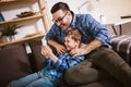 Father and cute little son using phone apps together, watching cartoons or video, playing game Royalty Free Stock Photo