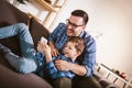 Father and cute little son using phone apps together, watching cartoons or video, playing game