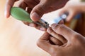 Father cutting fingernails for his baby on wooden table