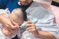 Father cutting my baby's nails with electic nail clipper while baby sleep