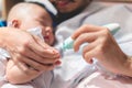 Father cutting my baby\'s nails with electic nail clipper while baby sleep