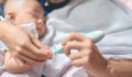 Father cutting my baby`s nails with electic nail clipper while baby sleep