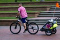 A father is cycling home with his kids on child trailer Royalty Free Stock Photo