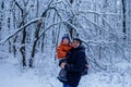 Father and his son playing outside, winter forest on the background, snowing, happy and joyful Royalty Free Stock Photo