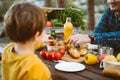 Father dad school kid boy child having a picnic in the forest camping site with vegetables, juice, coffee, and Royalty Free Stock Photo