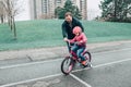 Father dad training helping girl daughter to ride bicycle. Preschooler child kid in pink helmet with bike Royalty Free Stock Photo