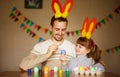 Father and daughter in bunny ears with colorful eggs in busket. Easter day. Modern Family preparing for Easter. Royalty Free Stock Photo