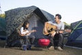 Father and daughter at camping playing ukulele