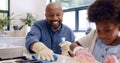 Father, daughter and cleaning with glove in kitchen for bonding, happiness and teaching in home or house. Black family Royalty Free Stock Photo