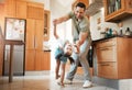 A father and daughter dancing in the kitchen at home. Cute and happy little girl practicing a dance with her dad. Young Royalty Free Stock Photo