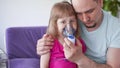 Father and daughter do inhalations. caring dad helps her daughter breathe through the mask Royalty Free Stock Photo