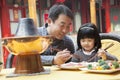 Father and daughter eating Chinese food outside