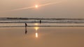 Beautiful silhoutte of Father and daughter enjoying sunset on a sea beach in their own way that makes them happy