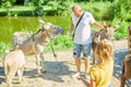 Father and daughter feeding donkeys in the countryside, in a farm