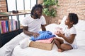 Father and daughter folding clothes to donate at bedroom