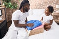 Father and daughter folding clothes to donate at bedroom