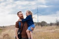 Father with daughter in hands standing on hill with nature lanscape. Little blonde girl smiling and hugging dad outdoor Royalty Free Stock Photo