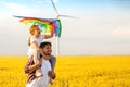 Father and daughter having fun, playing with kite together on the Wheat Field on Bright Summer day Royalty Free Stock Photo