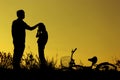 Father and daughter having fun riding bike at sunset, active family sport, active kids sport, Asian kid,Silhouette a kid at the su