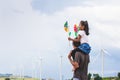 Father and daughter having fun to play together. Asian child girl playing with wind turbine and riding on father`s shoulders Royalty Free Stock Photo