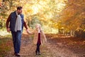 Father And Daughter Holding Hands On Family Walk Along Track In Autumn Countryside Royalty Free Stock Photo