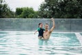 Father and daughter kid girl child swimming playing in the pool, smiling and laughing. Having fun in the pool at water park, Royalty Free Stock Photo