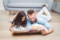 Father and daughter looking in picture book while lying on floor Royalty Free Stock Photo