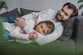 father and daughter lying on sofa and looking Royalty Free Stock Photo