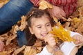 Father and daughter are lying on yellow leaves and having fun in autumn city park. They posing, smiling, playing. Bright yellow tr Royalty Free Stock Photo