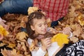 Father and daughter are lying on yellow leaves and having fun in autumn city park. They posing, smiling, playing. Bright yellow Royalty Free Stock Photo