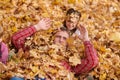 Father and daughter are lying on yellow leaves and having fun in autumn city park. They posing, smiling, playing. Bright yellow Royalty Free Stock Photo