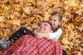 Father and daughter are lying on yellow leaves and having fun in autumn city park. They posing, smiling, playing. Bright yellow Royalty Free Stock Photo