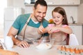 Father And Daughter Making Dough Baking Cake In Kitchen