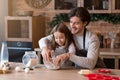Father and daughter making pastry in kitchen together, kneading dough