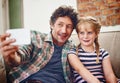 Father and daughter moments to treasure. a father and his little daughter taking a selfie together at home.