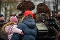 Father with daughter near a burnt and melted rusty wreckage of a Soviet Russian-made tank Royalty Free Stock Photo