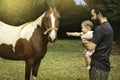 Father and daughter next to a horse