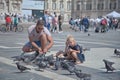 Father and daughter play with birds in Piazza Duomo in Milano