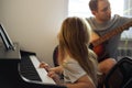 Father and daughter play musical instruments - piano and guitar - together. Family creative leisure Royalty Free Stock Photo