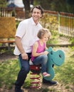 Father and daughter on playground spring rider