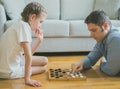 Family playing checkers board game. Royalty Free Stock Photo