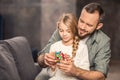 Father and daughter playing with cube