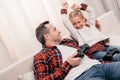 father and daughter playing with joysticks and smiling each other Royalty Free Stock Photo