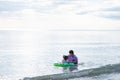 Father and daughter are playing in sea. Girl sitting on green raft. Father takes care of daughter. Royalty Free Stock Photo
