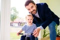 Father and daughter playing together, riding a bike indoors Royalty Free Stock Photo