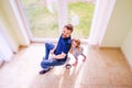 Father and daughter playing together, riding a bike indoors Royalty Free Stock Photo