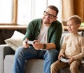 Father and daughter playing video games while spending time together at home Royalty Free Stock Photo