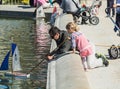 Father and daughter push toy sailboat in fountain in Luxembourg Garden, Paris, France