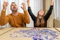Father and daughter screaming with raised hands desperate for the complexity of assembling a puzzle in the living room Royalty Free Stock Photo