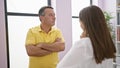 Father and daughter share a moment, standing, arms crossed, they look at each other deeply with love in their family home,